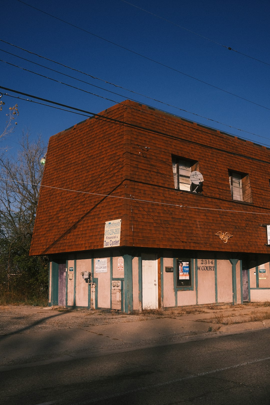 Home an-angular-building-with-a-shingled-roof-and-storefronts-abfwlr1oziu