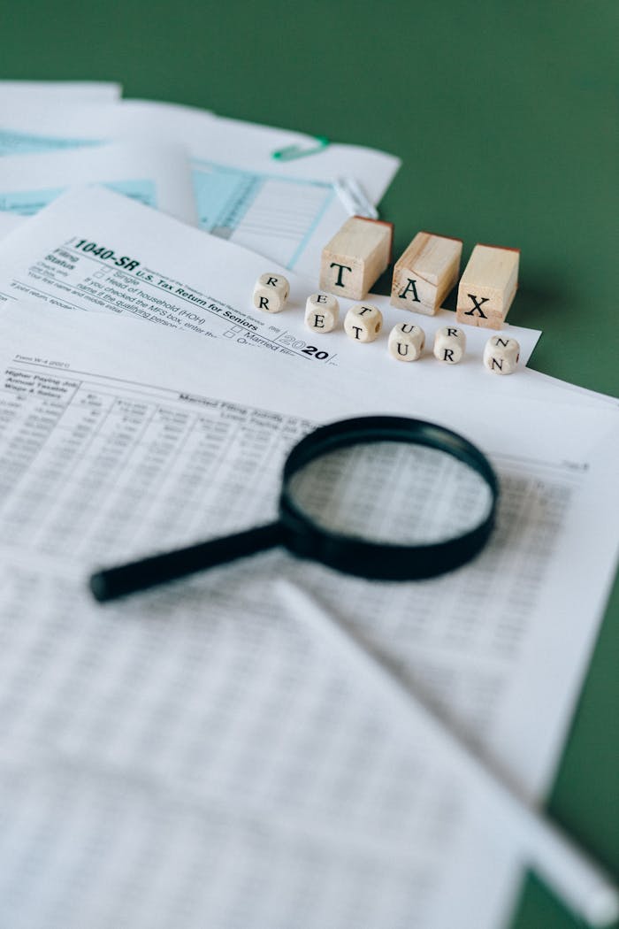 Home Financial documents and magnifying glass highlight tax season analysis.